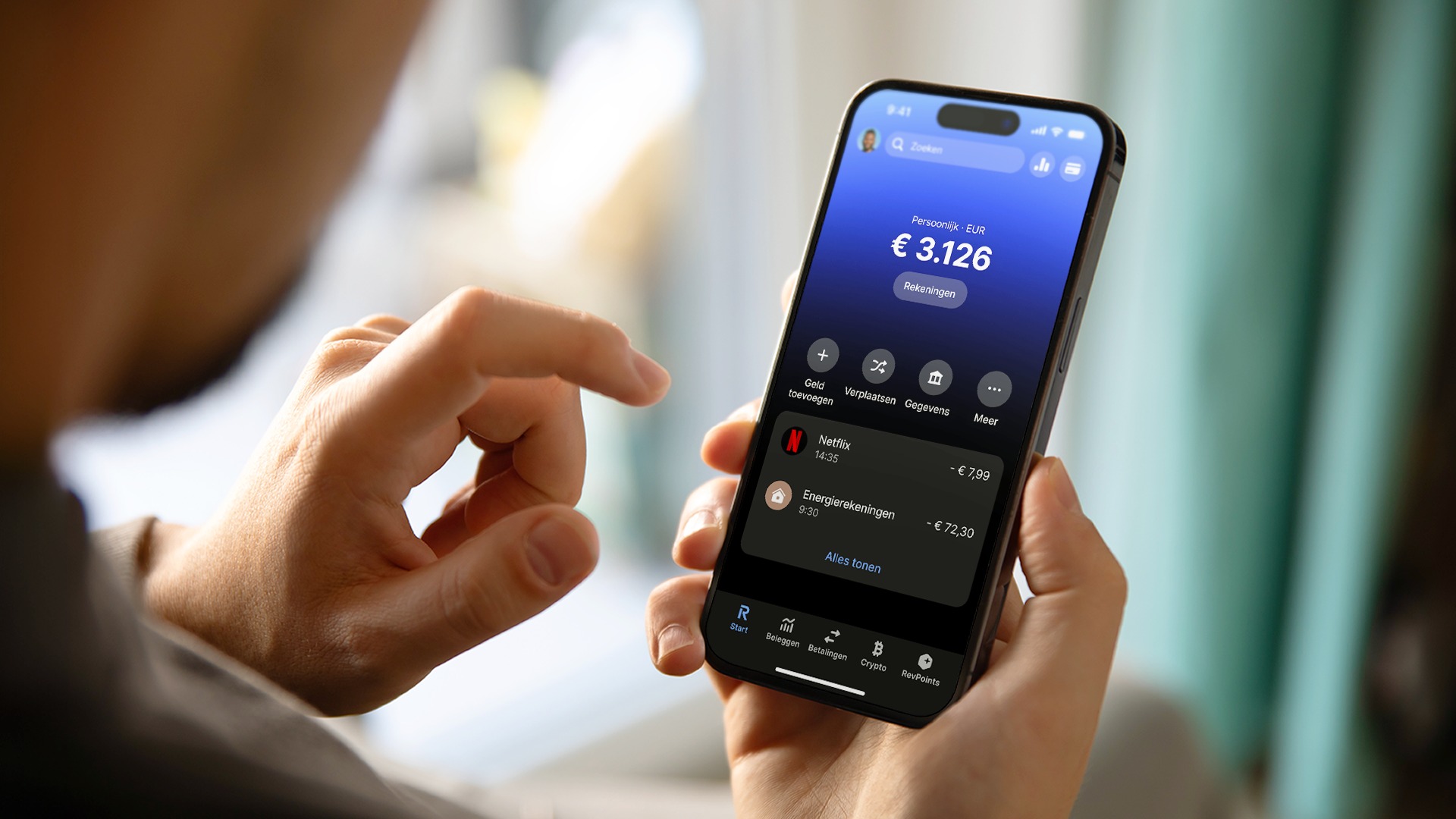 Archiefbeeld uit de perskit van Revolut: iemand bekijkt de Nederlandse bankapp op een telefoon.
