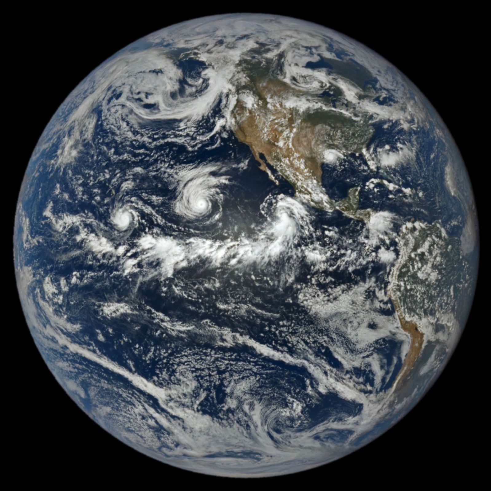 Satellietbeeld van de aarde met drie stormwervels boven de Stille Oceaan.