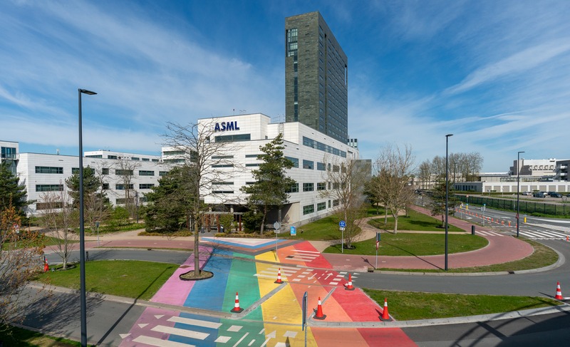 Archieffoto van de ASML-campus in Veldhoven, met kantoorgebouwen en een kleurrijke oversteekplaats op de voorgrond.
