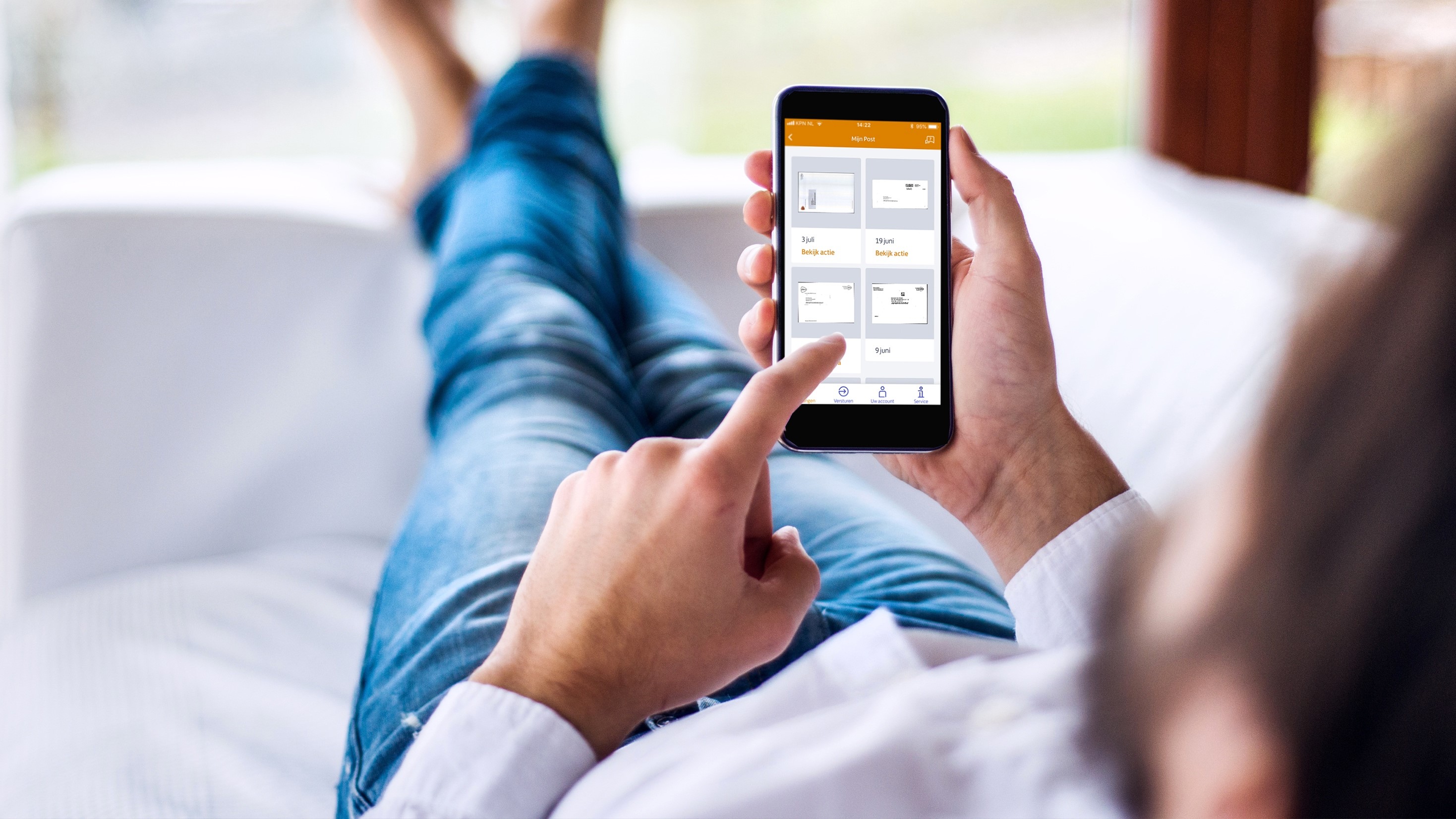Persfoto van PostNL: iemand bekijkt foto's van enveloppen in de MijnPost-app op een telefoon.