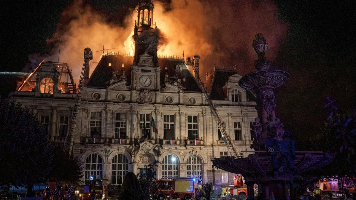 Het stadhuis van Limoges staat op 17 oktober in brand; brandweerladders staan tegen de gevel.