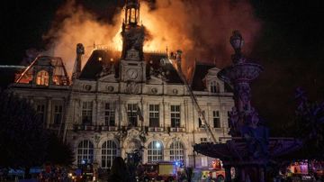 Het stadhuis van Limoges staat op 17 oktober in brand; brandweerladders staan tegen de gevel.