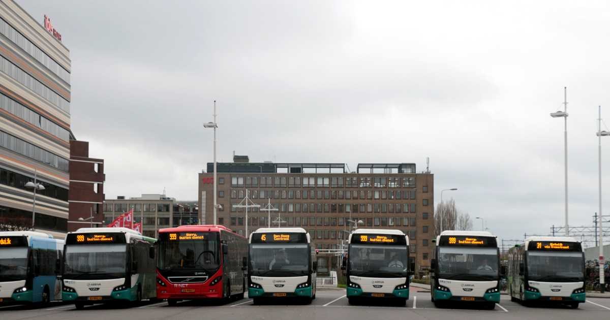 Een rij streekbussen staat naast elkaar op een plein, met bij meerdere bussen buiten dienst op het scherm.