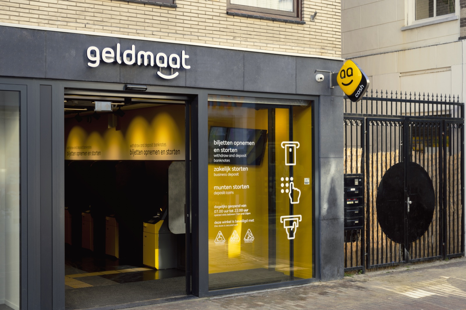 Een Geldmaatwinkel met opnameautomaten achter een glazen pui, op een officiële archieffoto.